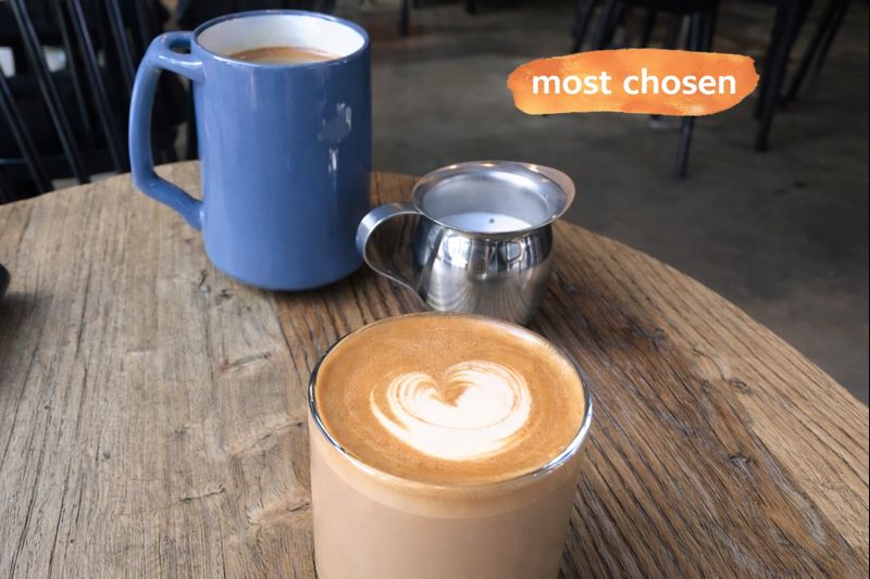 Latte with heart-shaped art on wooden table in Seoul cafe
